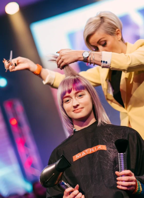 Kaderníčka Matrix s nožnicami pri farbení vlasov.